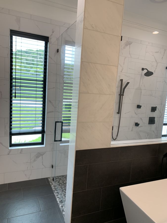 Master bath with marble look porcelain and charcoal wainscot
