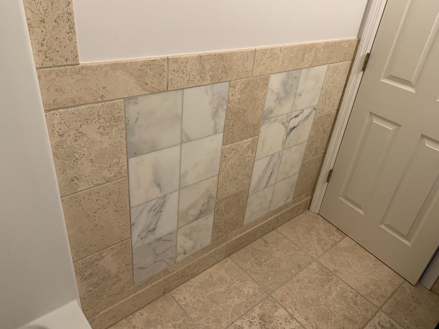 Travertine wainscot with inset Calacatta marble panels